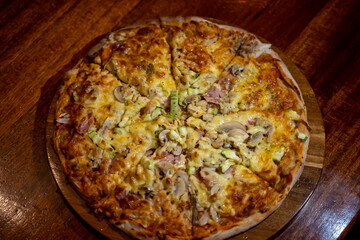 Aerial photo of a pizza with mushrooms, vegetables and meat.