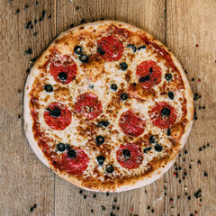 Pepperoni pizza with olives. sprinkled pepper on the table