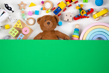 Top view to baby kids toys. Set of colorful educational wooden and fluffy toys and blank green...