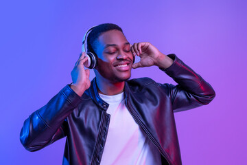 Fototapeta premium Music Lover. Handsome Black Guy In Wireless Headphones Listening His Favorite Songs