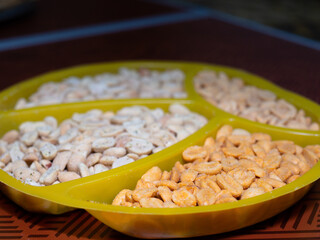 salted peanuts in spices with different flavors on the table in a bowl. beer snack