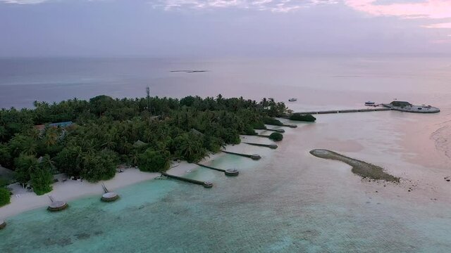 Hideaway resort in the Maldives. drone shot of the iseland and the turquoise water.Sunset.