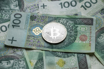 Bitcoin BTC cryptocurrency coin on polish money PLN background.