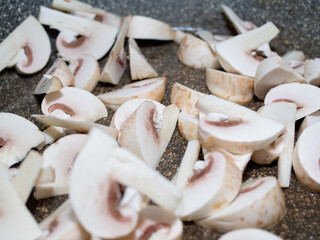 sliced raw mushrooms in a frying pan. cooking dinner.