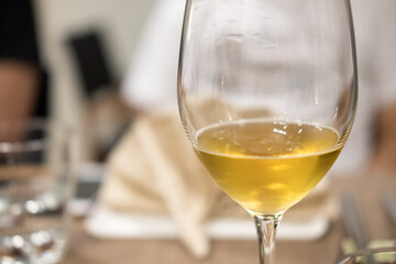 A glass of wine on the table, with blur background in the restaurant
