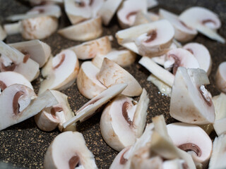sliced raw mushrooms in a frying pan close-up. cooking dinner.