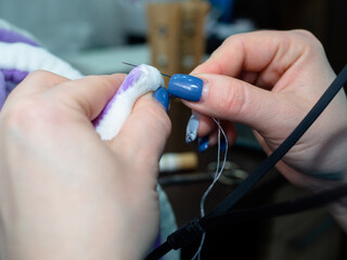 a woman sews a soft toy with a needle