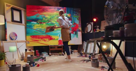 Back view of young talented concentrated Caucasian female professional artist painting drawing on big canvas in art studio in evening, creativity craft, creative painter, contemporary art concept - Powered by Adobe