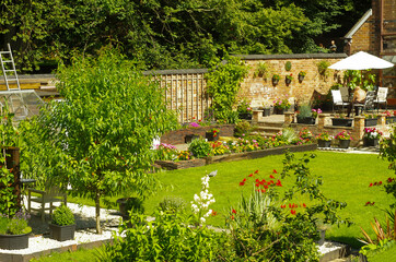 Fototapeta na wymiar Hard landscaping, new luxury stone patio and garden of an English home, UK. summertime in english backyard