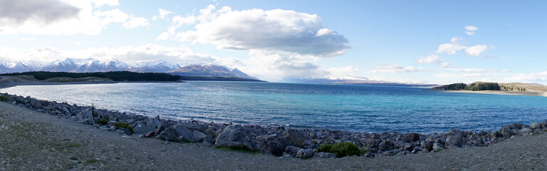 Lake Tekapo with nearby snow covered mountain peaks on a sunny day in the South Island of New...
