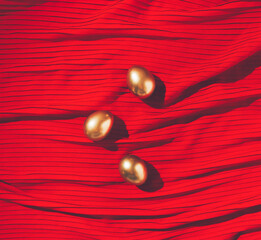Golden Easter Eggs on red luxury background. Minimal flat lay