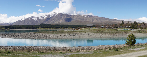 Lake Tekapo with nearby snow covered mountain peaks on a sunny day in the South Island of New...