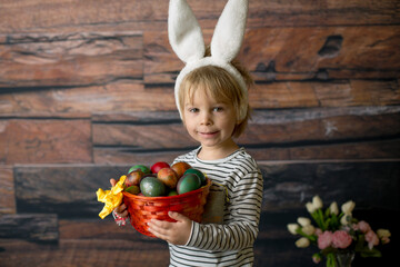 Fototapeta premium Sweet toddler child, cute boy playing with colorful easter eggs