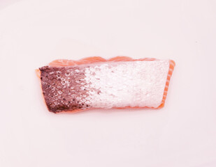 Single salmon steak on white background with skin side up
