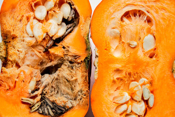 A pumpkin cut in half, left half is rotten, right half - good quality, on a white background