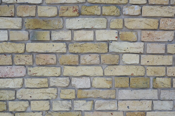 Peeled old brick wall. Brick yellow background.