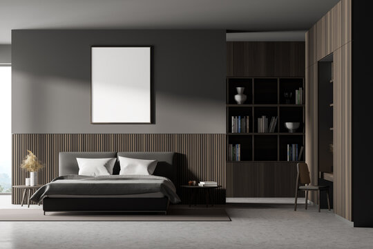 Front view of a bedroom with king size bed, a bookshelf, a table and a chair. Large vertical poster is hanging above the bed. 3d rendering. Mock up.