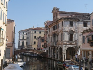 Fototapeta na wymiar Chioggia, Vena Canal with colorful ancient buildings on both sides and Grassi Palace