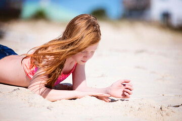 Tween red haired girl in swimsuit at the beach