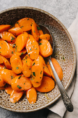Closeup of a bowlful of glazed carrots