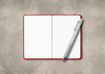 Red open lined notebook with a pen isolated on concrete background