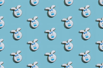Food banner. Seamless pattern. Covid protection. Bakery art. Abstract background. Bunny gingerbread cookies with white icing and medicine mask ornament isolated on blue textured.