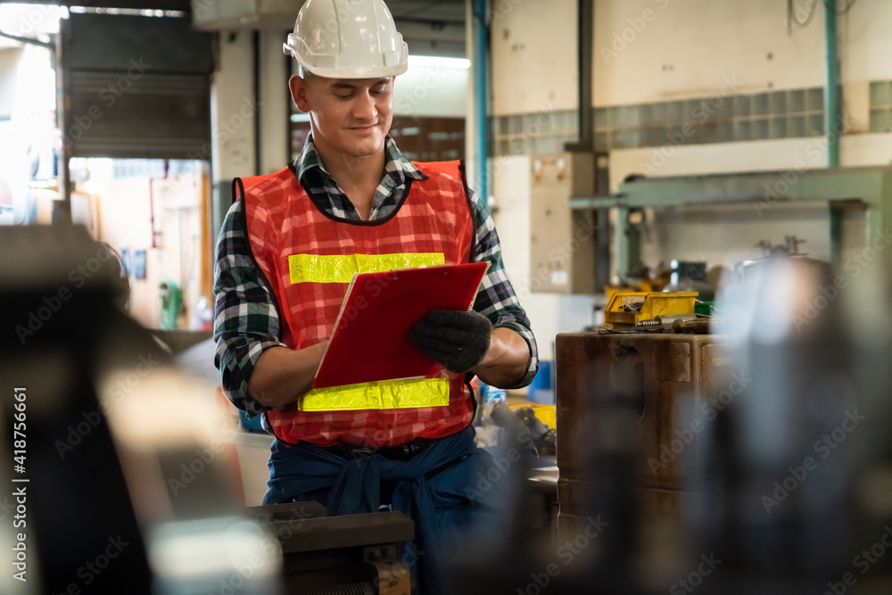 Poster manufacturing worker working with clipboard to do job procedure checklist . factory production line 