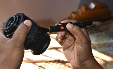 Close up of man hands cleaning camera lens with brush or lens pen cleaner.