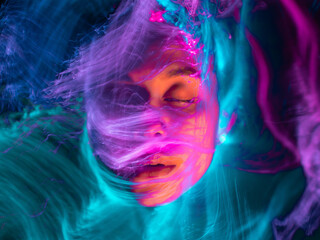 Abstract portrait of a girl in multicolored smoke, light painting photo