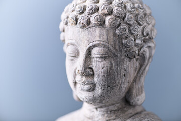 Meditating Buddha Statue on bright background. Close up. 