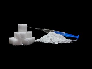 Injection syringe on cocaine drug powder pile and lump sugar cubes on black background, sugar is more addictive than cocaine, isolated cubes of white sugar and cocaine on black background