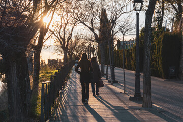 Mature mother and young daughter walking along the Paseo de las Murallas de Baeza (Spain) in the...