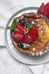 Homemade cheesecake with blueberries, currants, strawberries and mint leaves from above. Flat lay