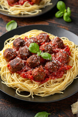 Vegetarian spaghetti with meat free, vegan meatballs in rich tomato sauce, grated cheese and basil leaves