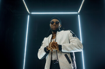 Stylish rapper in sunglasses, dark background