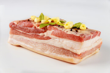 Piece of raw pork belly with garlic isolated on white background.