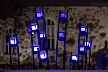 Lighted blue decorations with the wall of a stone church in the background