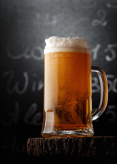 Glass of light beer on a rustic wooden table
