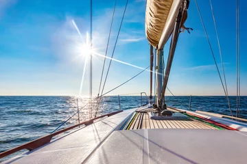 Schilderijen op glas Sailing boat at calm open sea on a bright sunny day © thakala