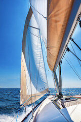 Sailing boat at open sea on a bright sunny day, vertical