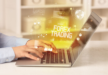 Side view of a business person working on laptop with FOREX TRADING inscription, modern business concept