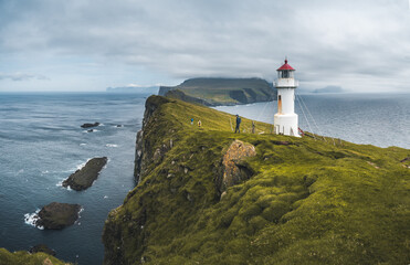 Fototapeta na wymiar View Towards Lighthouse on the island of Mykines Holmur, Faroe Islandson a cloudy day with view towards Atlantic Ocean.