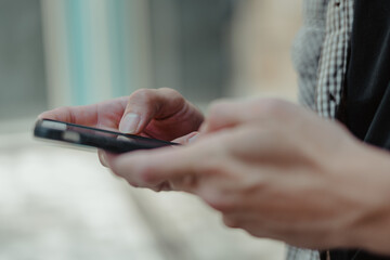 Close-up image of male hands using smartphone, searching or social networks concept, man typing an sms message to his friends.