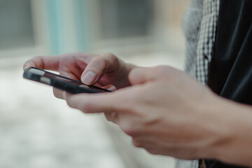 Close-up image of male hands using smartphone, searching or social networks concept, man typing an sms message to his friends.