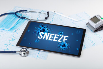 Tablet pc and doctor tools on white surface with SNEEZE inscription, pandemic concept