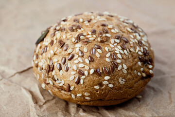 bun with cereals on craft paper close-up