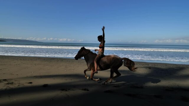 epic shot woman on a galloping horse hands free no saddle Costa Rica beach zancudo