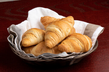 Butter croissants on a serviette in a basket to serve for breakfast