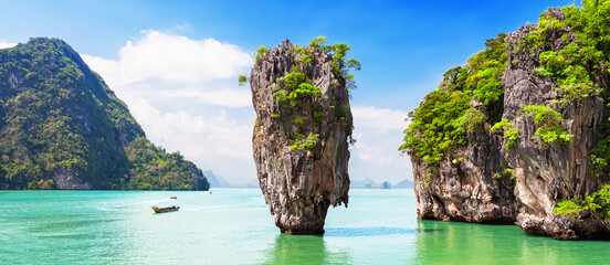 Travel photo of James Bond island with thai traditional wooden longtail boat in Phang Nga bay, Thailand. © preto_perola