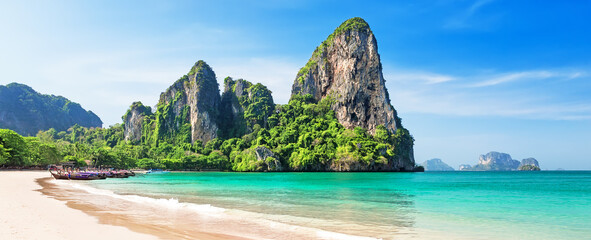 Panorama of beautiful sand Railay beach and thai traditional wooden longtail boat in Krabi province, Thailand.